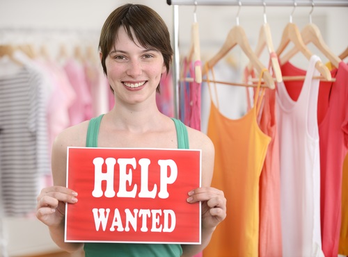 retail-store-owner-holding-help-wanted-sign.jpg
